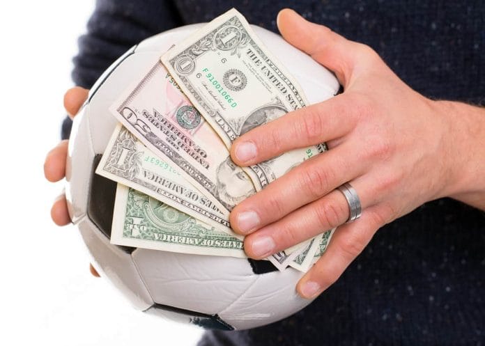 hands with soccer- ball and money